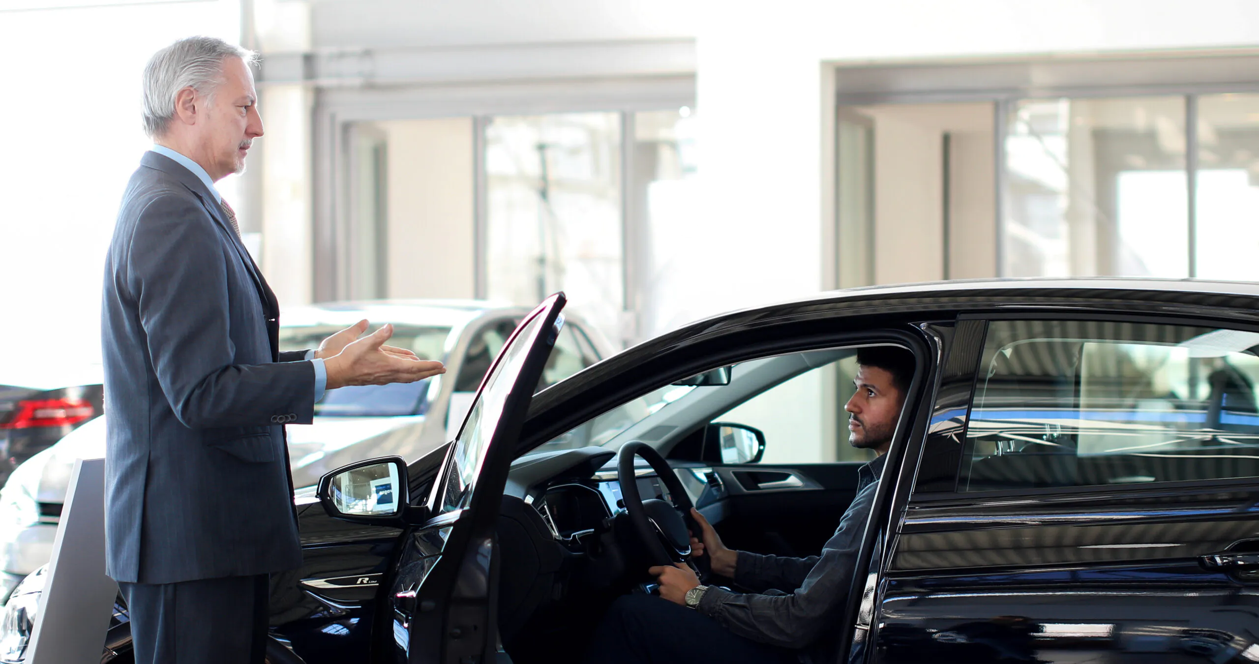car dealer opening car s door customer scaled 1