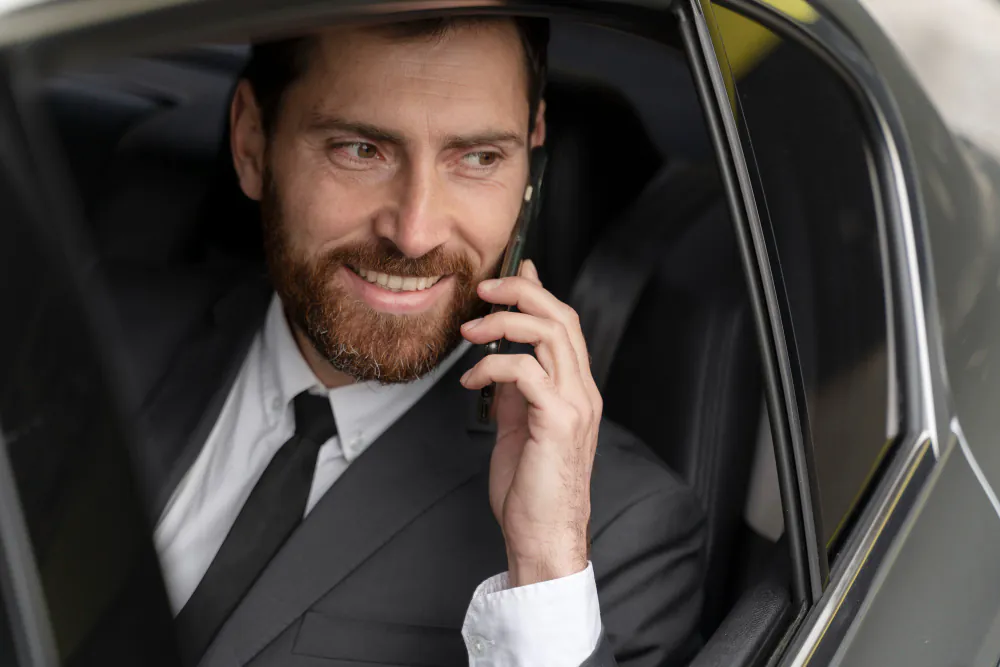 executivo conversando ao telefone dentro de carro blindado